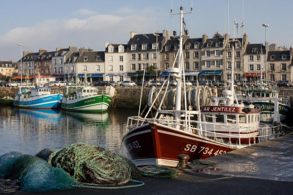Port de pêche de Concarneau : chalutiers colorés à quai, filets et façades du quai