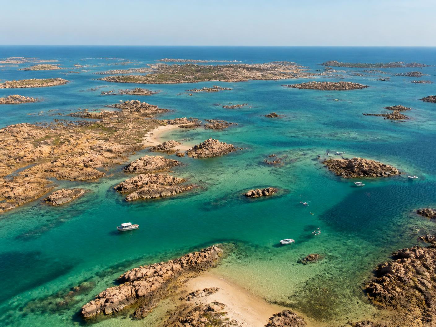 Illustration vue du ciel d'un archipel de granit au large de Granville : eau turquoise, îlots et bancs de sable