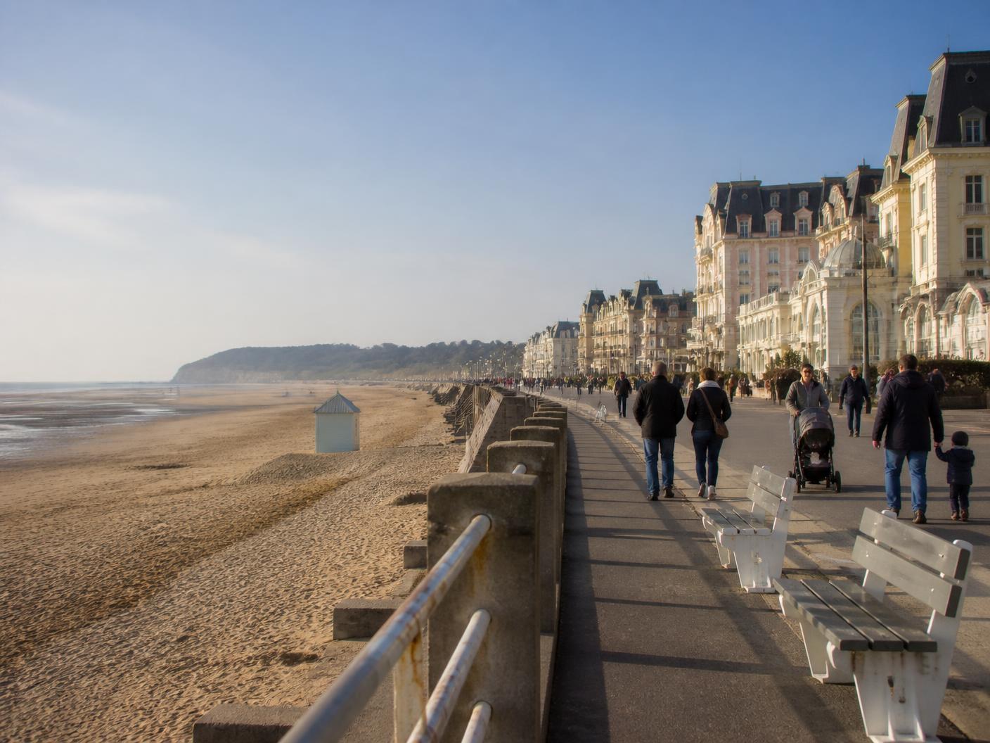 Illustration du front de mer granvillais : digue-promenade, plage de sable à marée basse et façades balnéaires