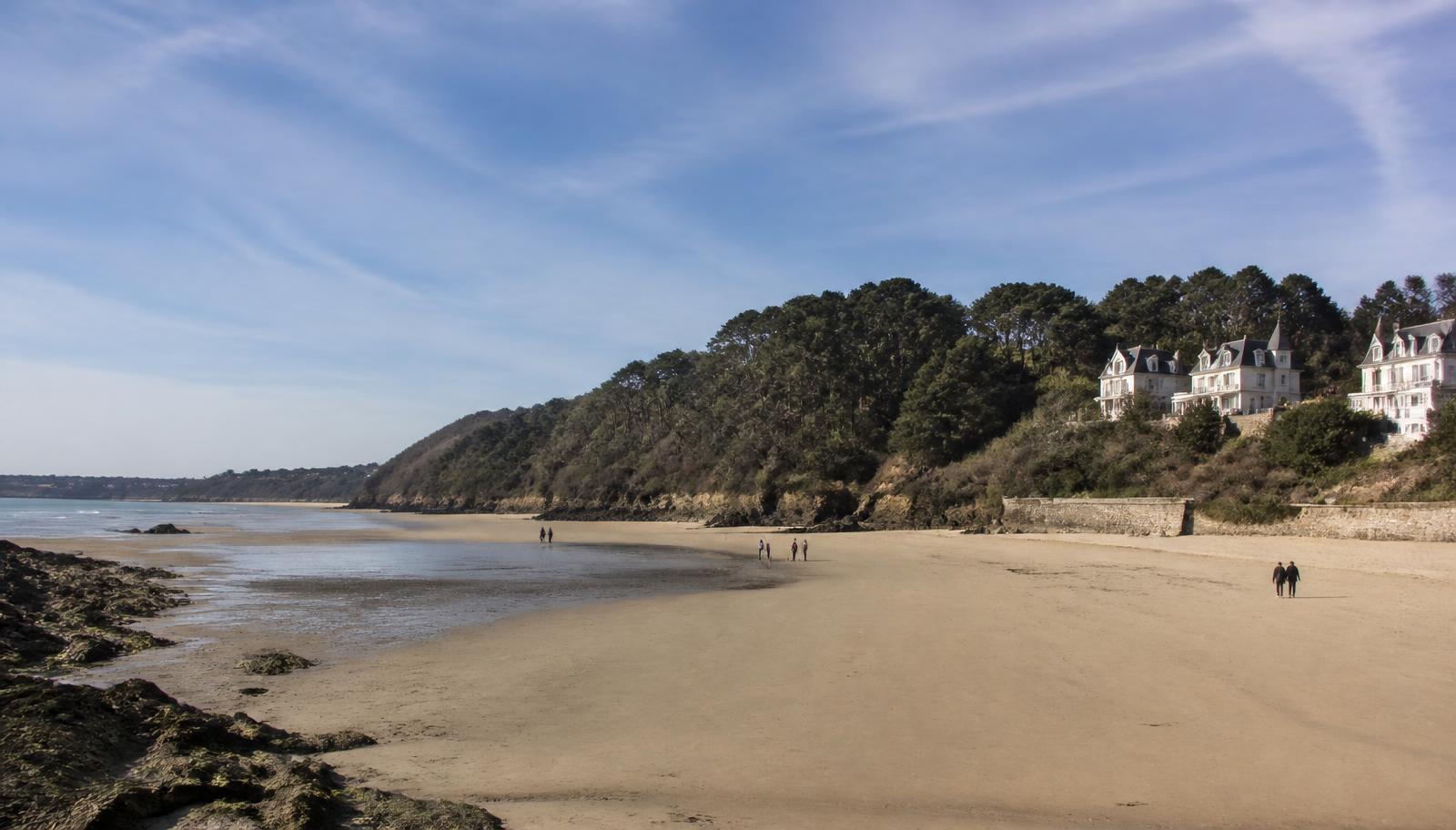 Illustration de la plage des Rosaires à Plérin : longue plage de sable, falaises boisées et villas balnéaires