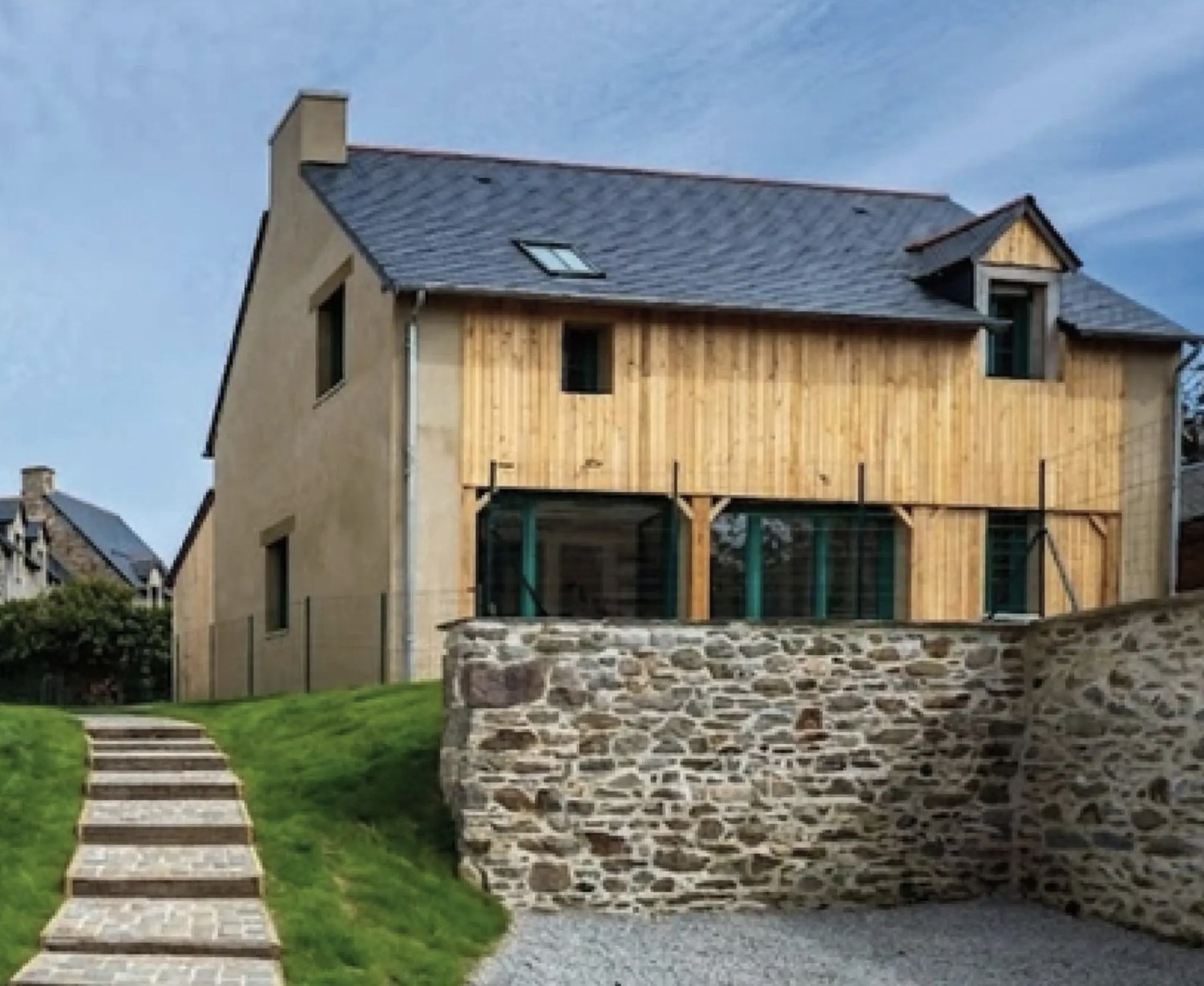 Maison neuve du programme Le Hameau à Saint-Suliac : bardage bois, enduit clair, toiture d'ardoise et mur de pierre
