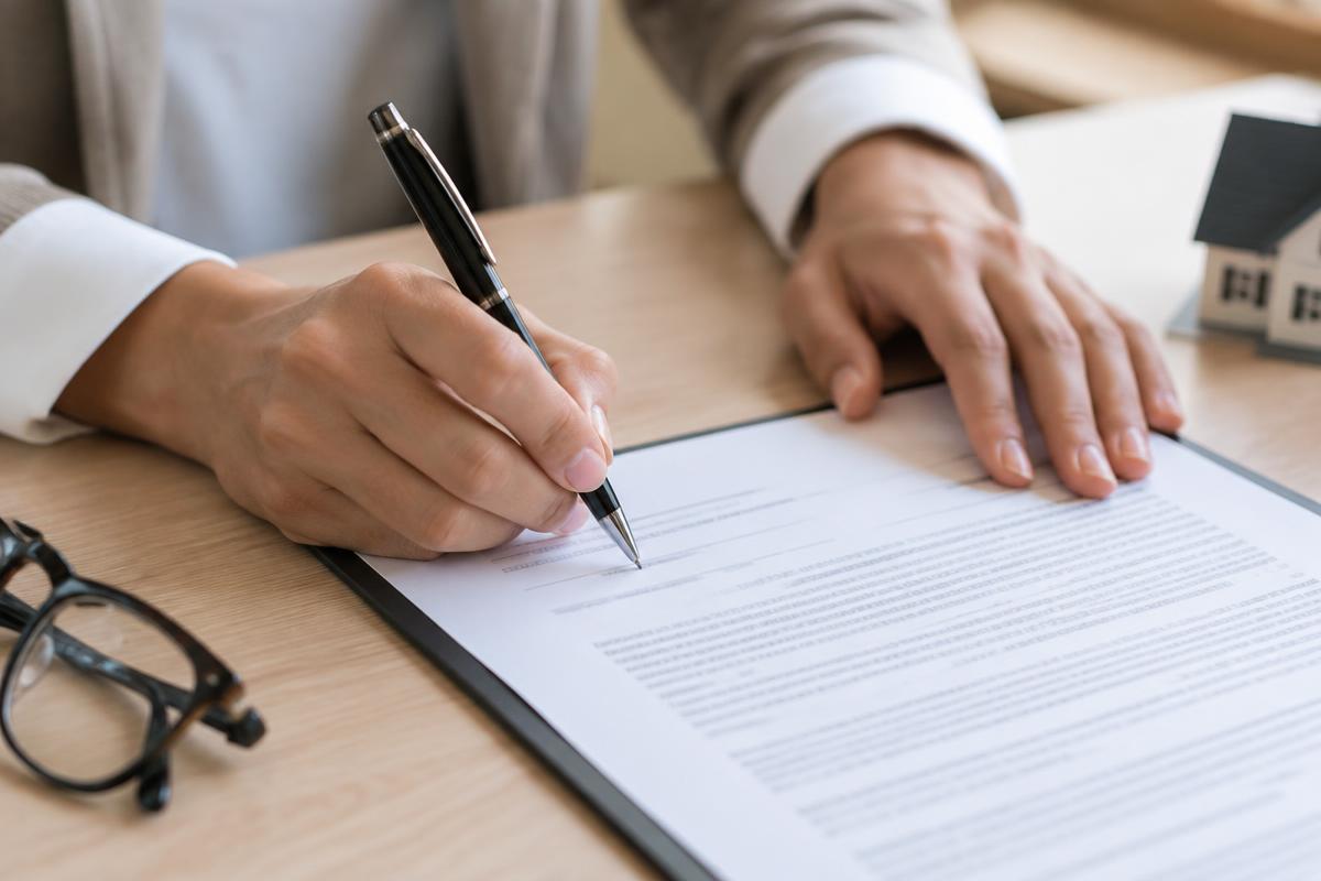 Signature d'un contrat d'assurance emprunteur sur un bureau clair