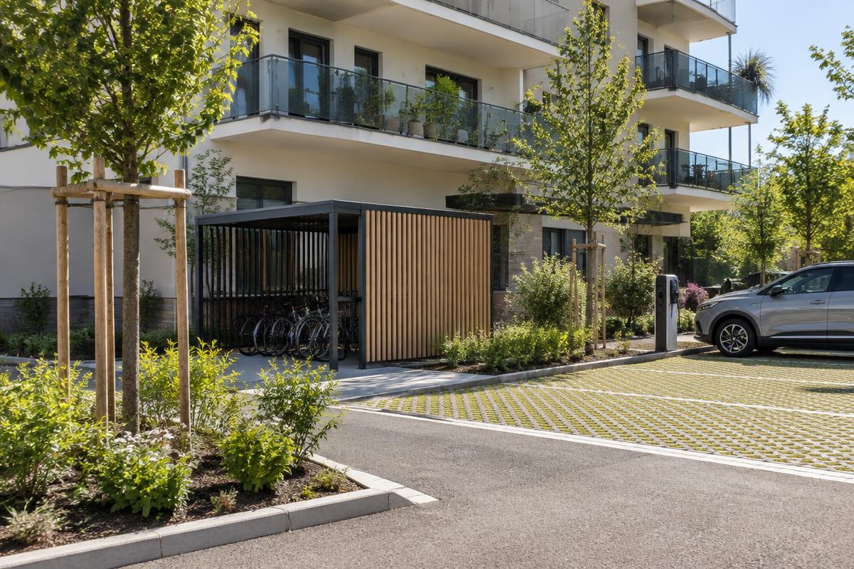 Local à vélos et stationnement paysager au pied d'une résidence neuve