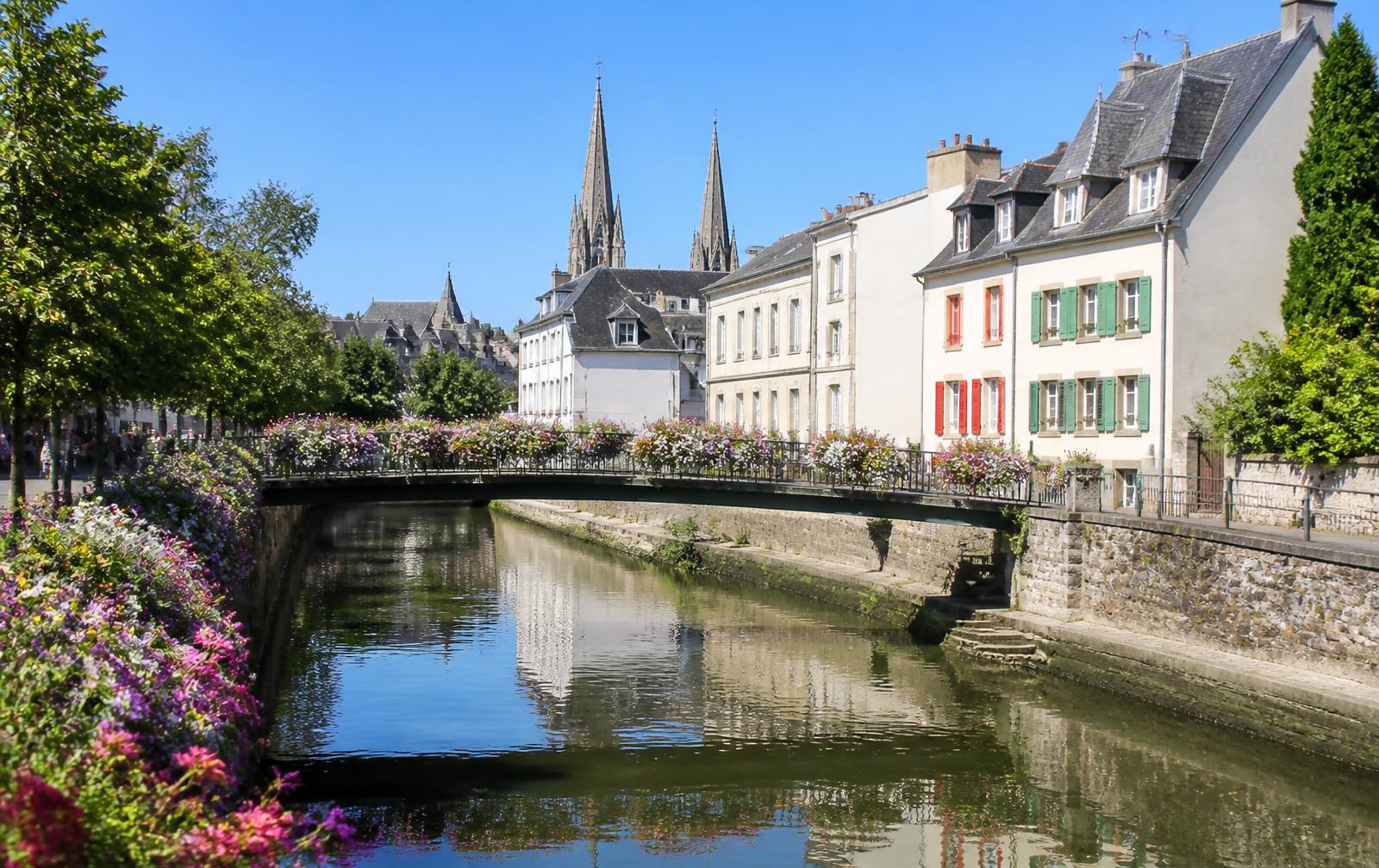 Illustration des quais de l'Odet à Quimper : passerelles fleuries, maisons anciennes et promeneurs