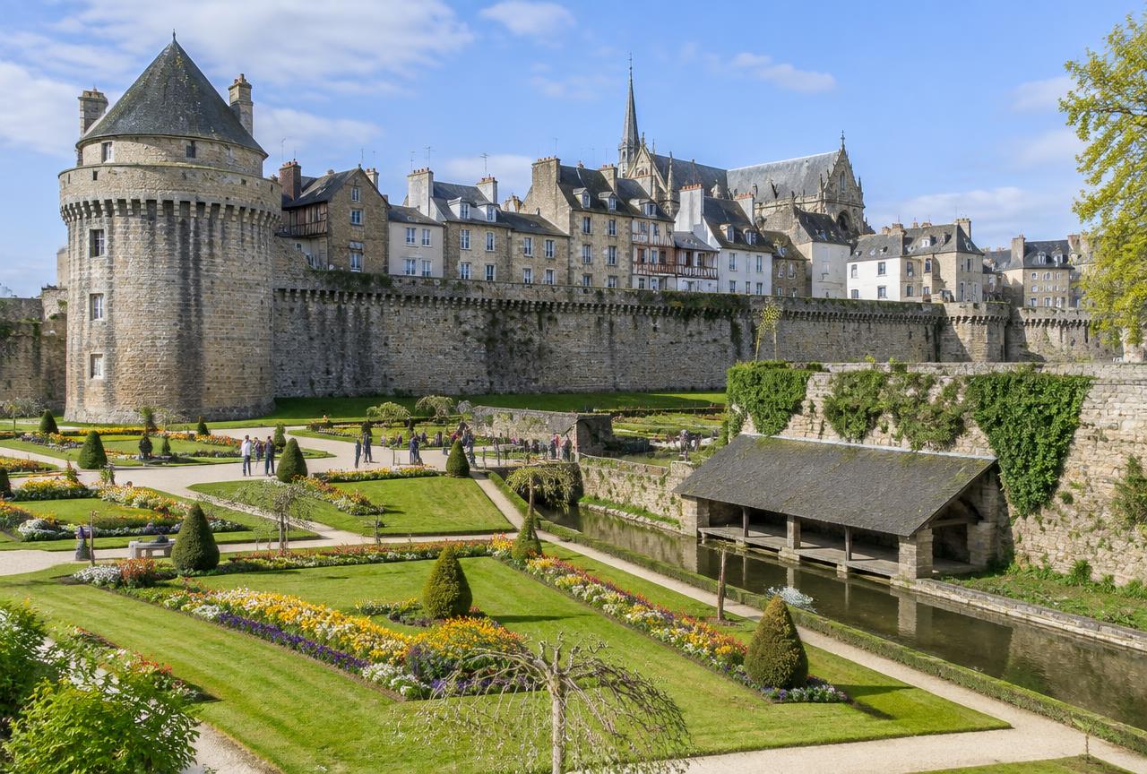 Illustration des remparts et des jardins de Vannes : muraille de pierre, parterres fleuris et lavoirs